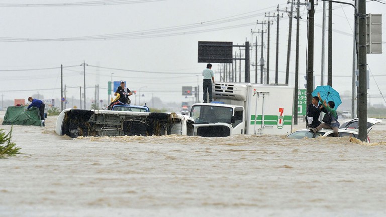 People wait for rescue on the roofs of cars as they are stranded on a road flooded by the Kinugawa river, caused by typhoon Etau in Joso, Ibaraki prefecture, Japan, in this photo taken by Kyodo September 10, 2015.